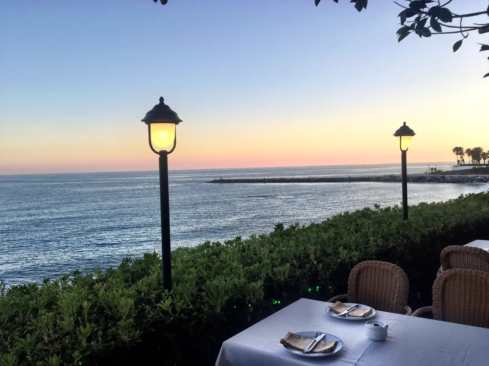 Mesa preparada frente al mar al atardecer